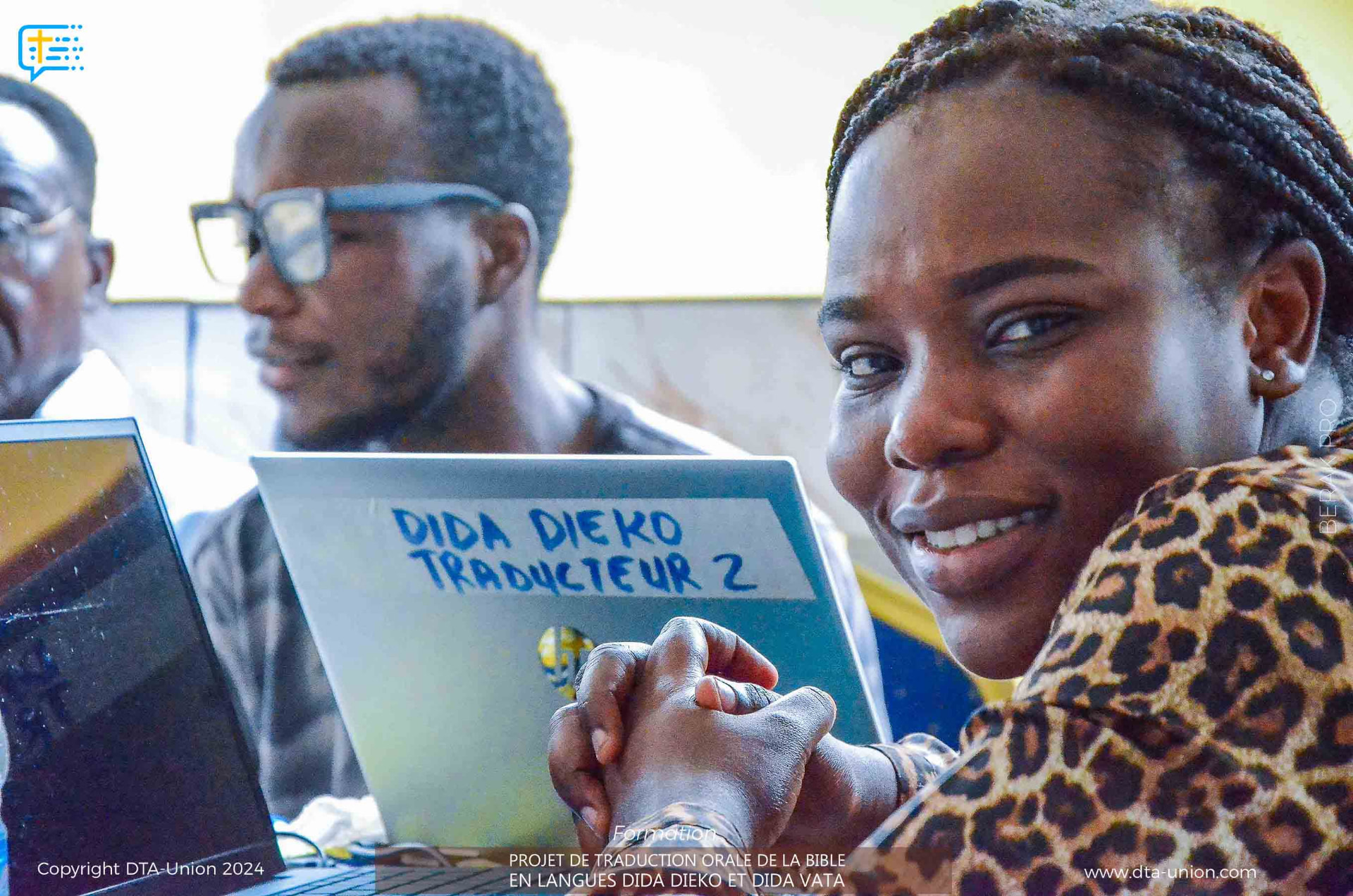 Une traductrice de l'équipe Dida Dieko souriante devant son ordinateur portable pendant l'atelier de Divo