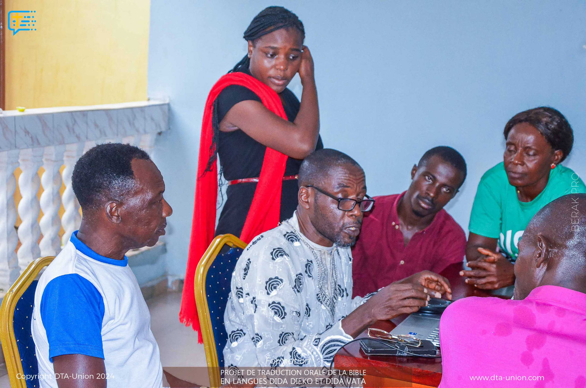 Travail d'équipe autour d'un ordinateur pendant l'atelier de traduction orale à Divo