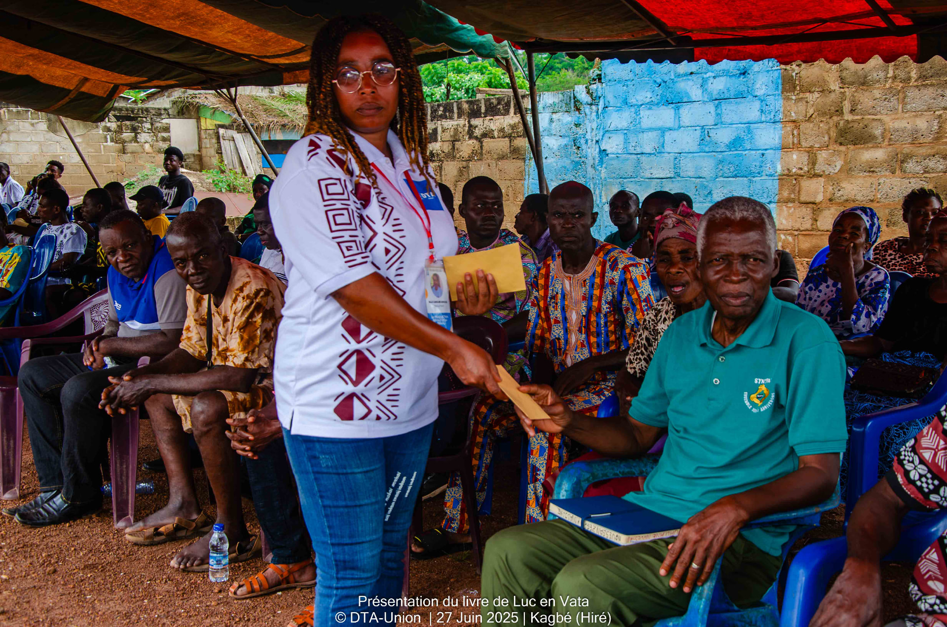 Remise d'une enveloppe à un notable lors de la présentation du livre de Luc en Vata à Kagbé