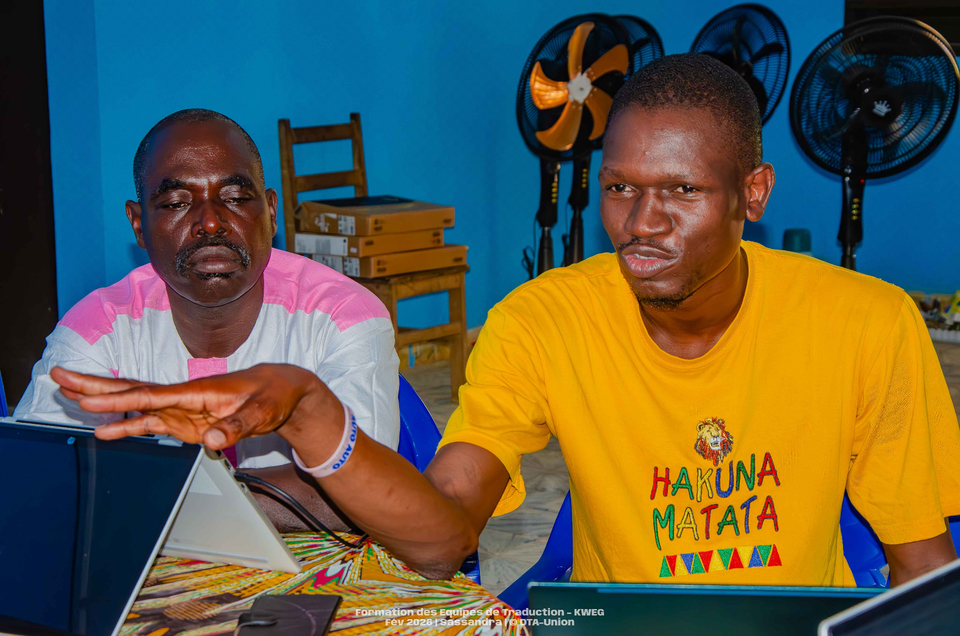 Deux traducteurs échangeant devant leurs ordinateurs lors de l'atelier de Sassandra
